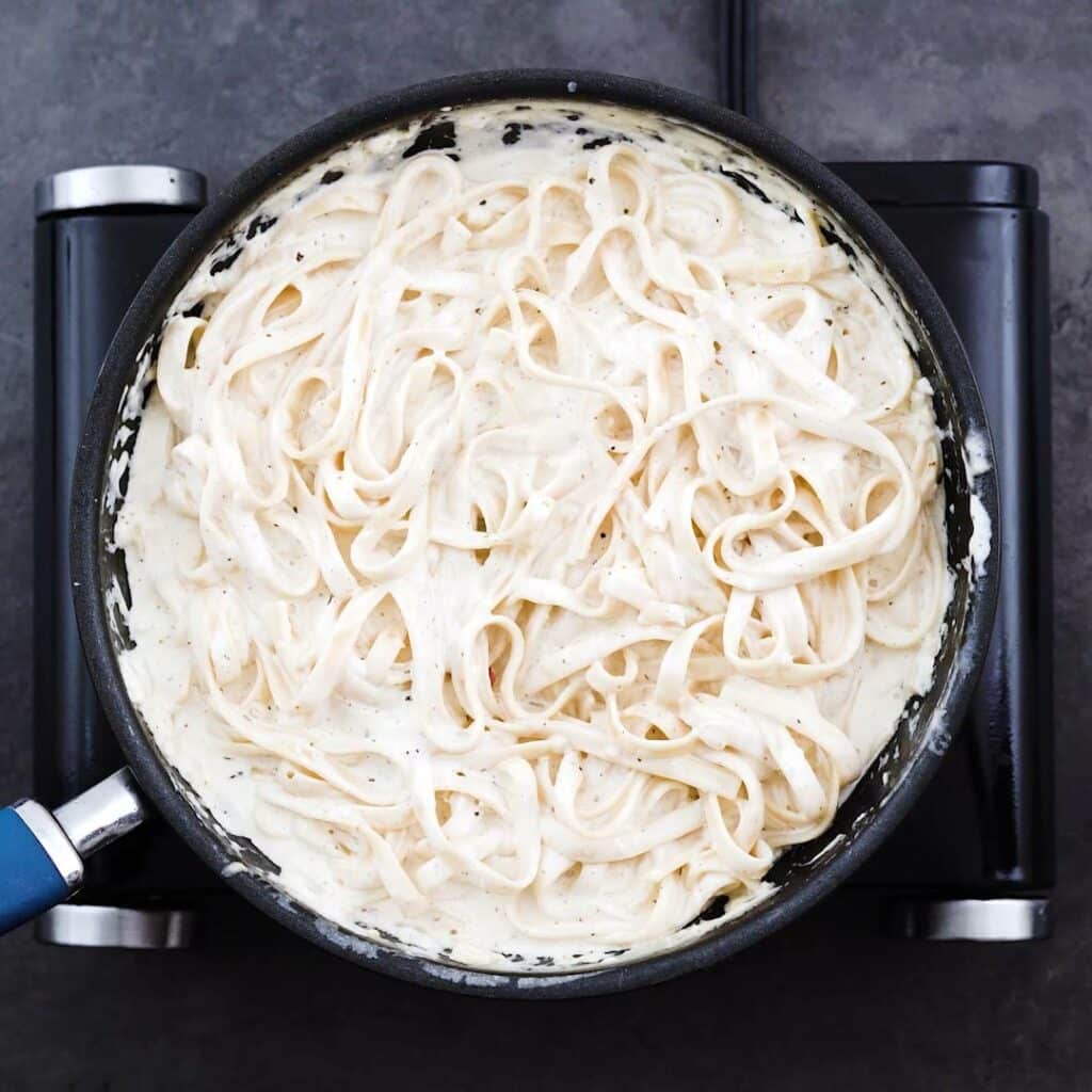 Pasta coated with alfredo sauce.