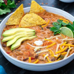 Homemade Vegetarian Chili in a white bowl with few ingredients around.