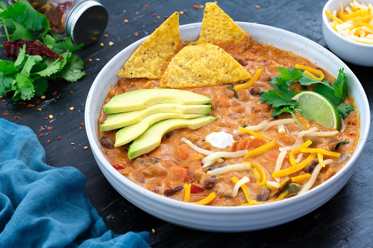 Homemade Vegetarian Chili in a white bowl with few ingredients around.