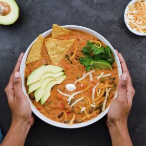 Serving the Vegetarian Chili with avocado, tortilla chips, cheese and sour cream.