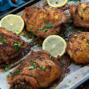 Baked chicken thighs in a baking tray.