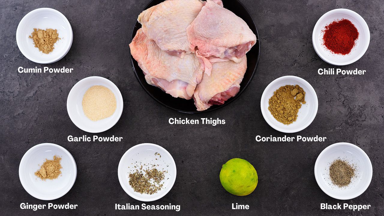 Baked chicken thighs ingredients arranged on a grey table.