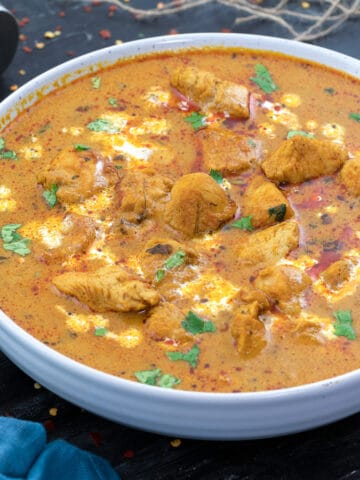 A white bowl filled with Indian chicken curry.