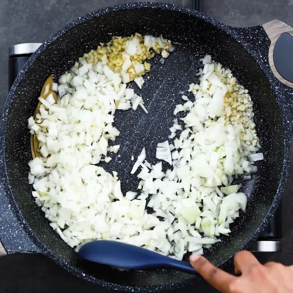 Sauteing the aromatics in a pan.