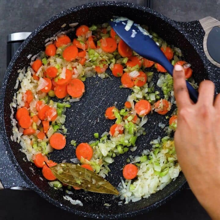 Sauteing the vegetables in a pan.