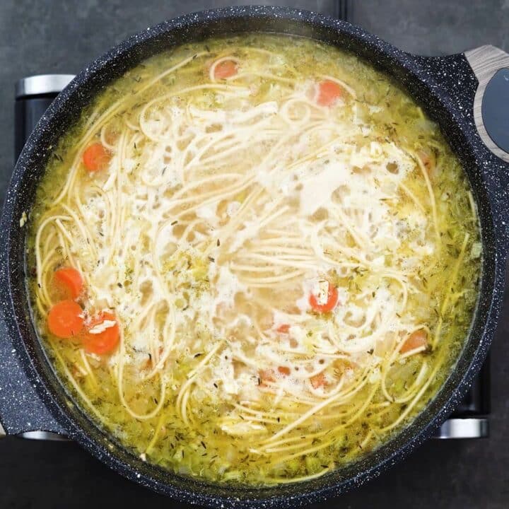 Chicken Noodle soup simmering in a pan.