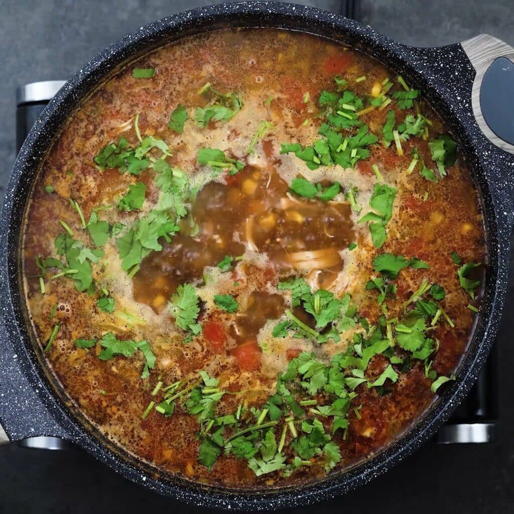 Chicken tortilla soup garnished with cilantro.