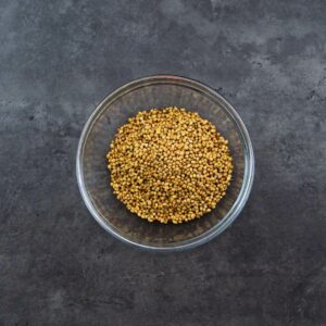Roasted coriander seeds in a glass bowl.