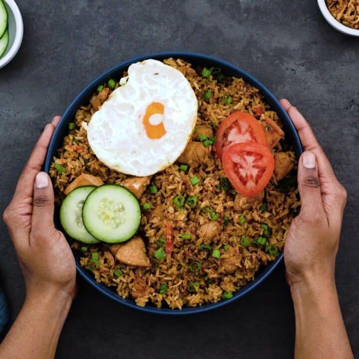 Serving Nasi Goreng with fried egg, fried onions and veggies.