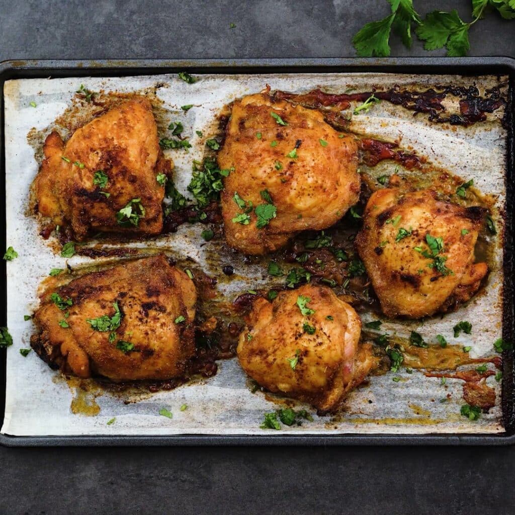 Oven Baked Chicken thighs garnished with coriander leaves.