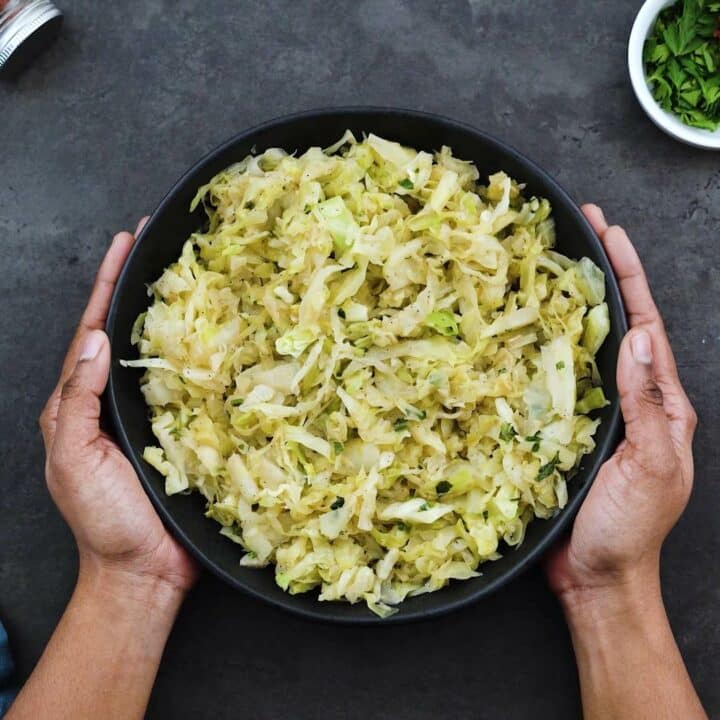 Serving sauteed cabbage in a black bowl.