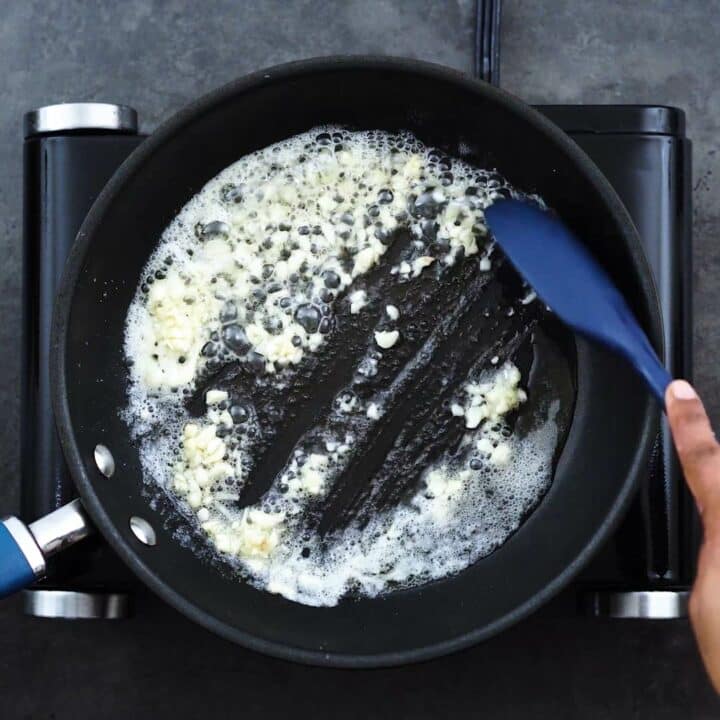 Sauteing the garlic in butter in a frying pan.