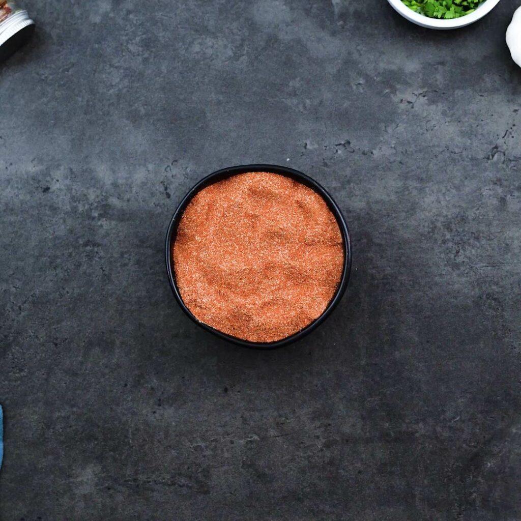 A black bowl with homemade fajita seasoning spice mix.