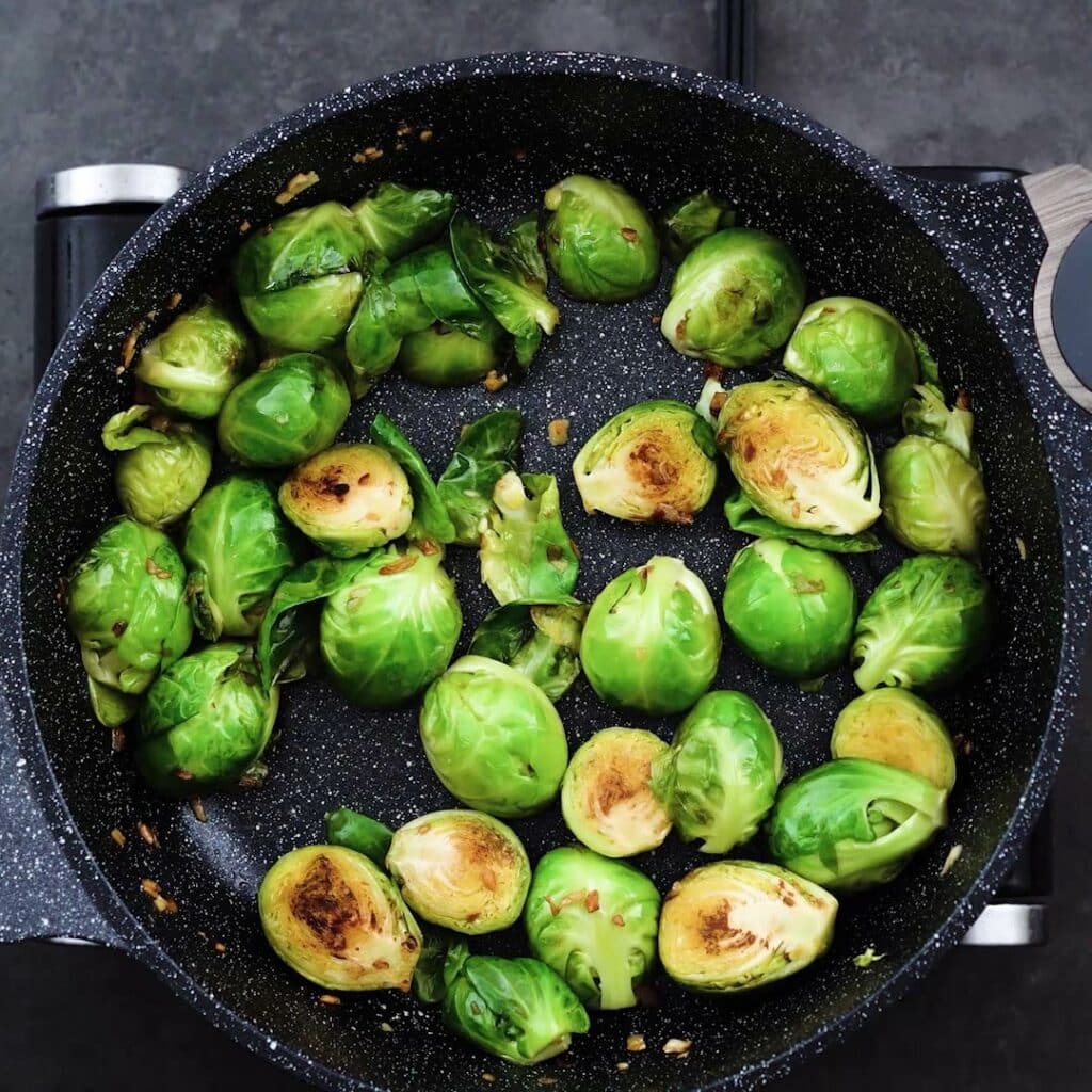 Golden brown brussels sprouts in a pan.