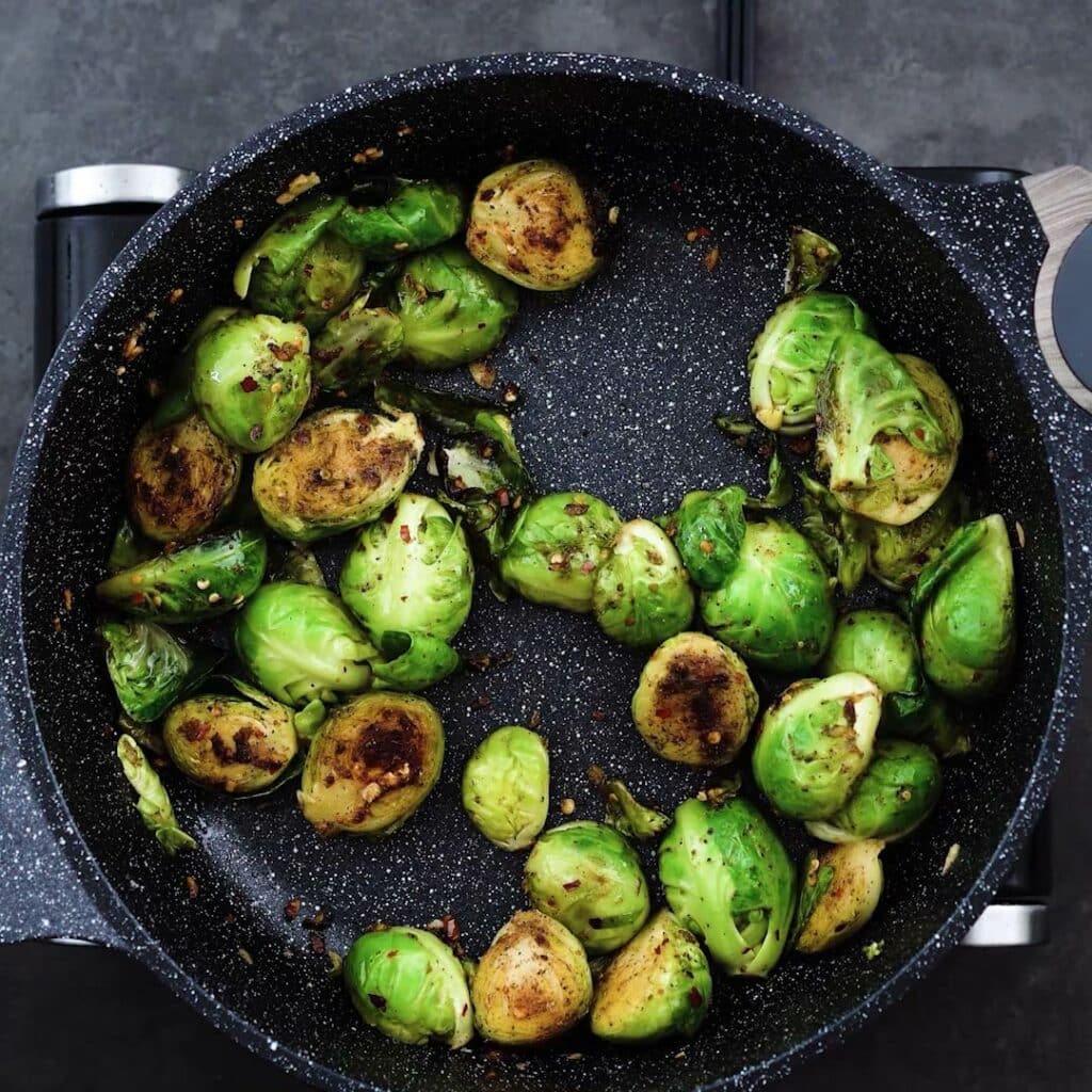 Sauteed Brussels Sprouts in a pan.