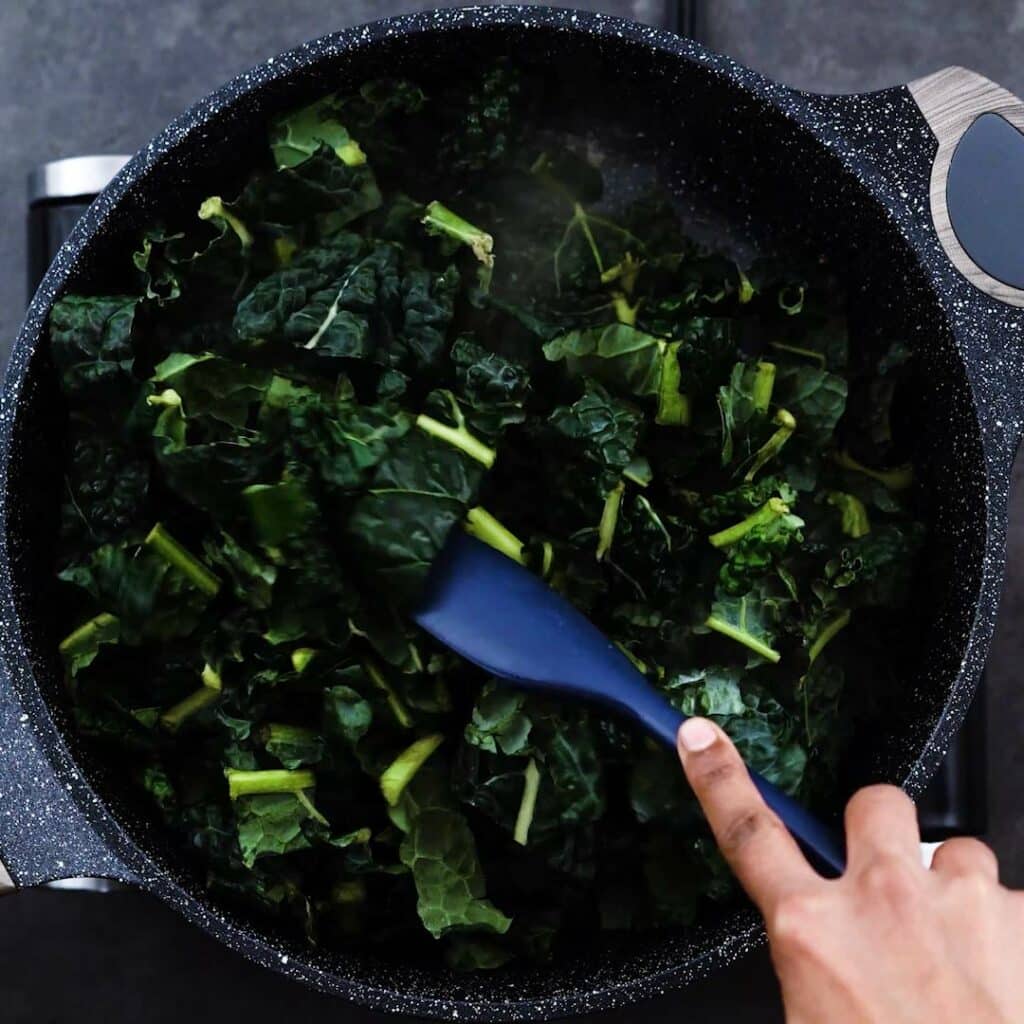 Sauteing Kale in a pan.