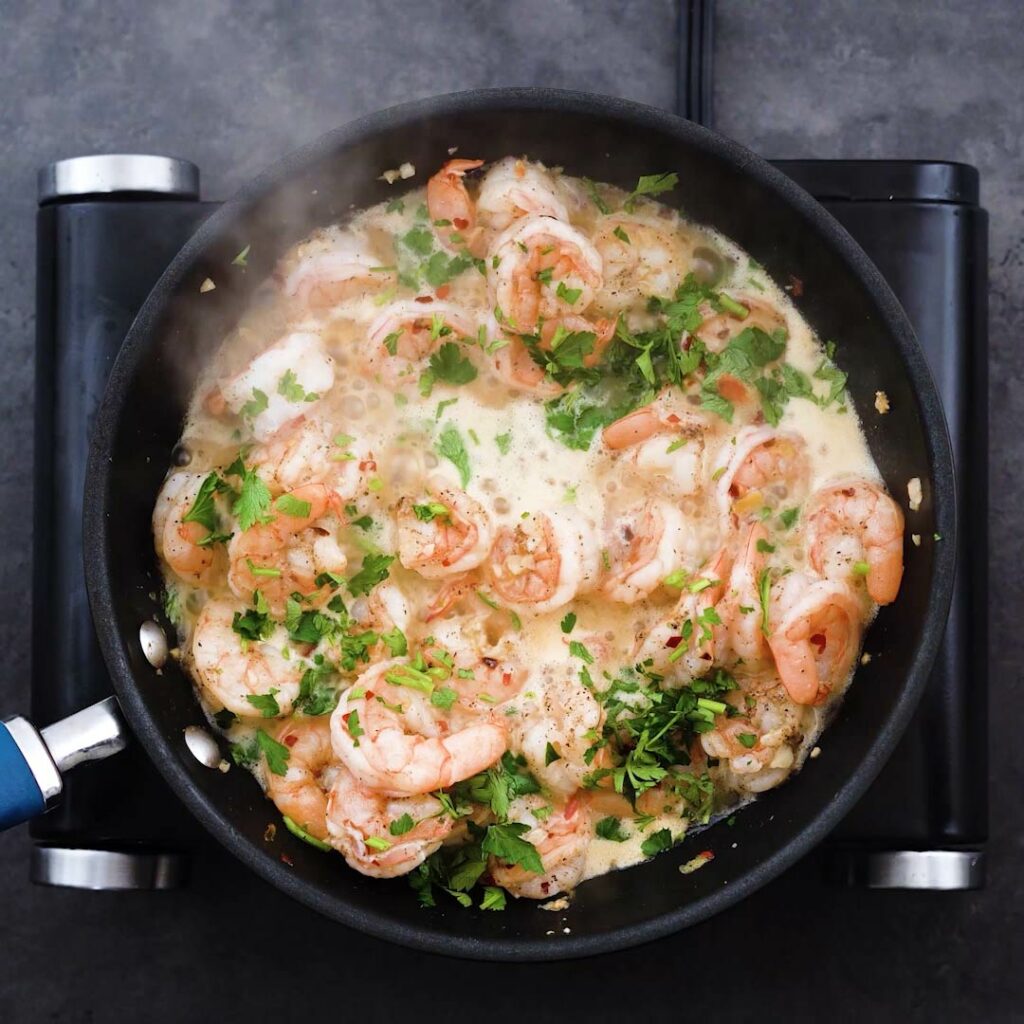 Shrimp Scampi garnished with fresh parsley in a pan.