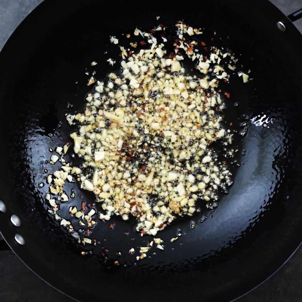 A wok with aromatics sizzling.