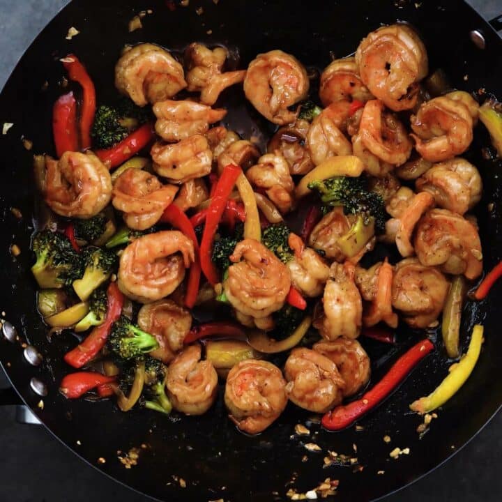 A wok with stir fried veggies and shrimp.