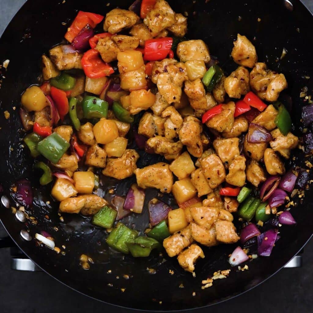 A wok with sweet and sour chicken.