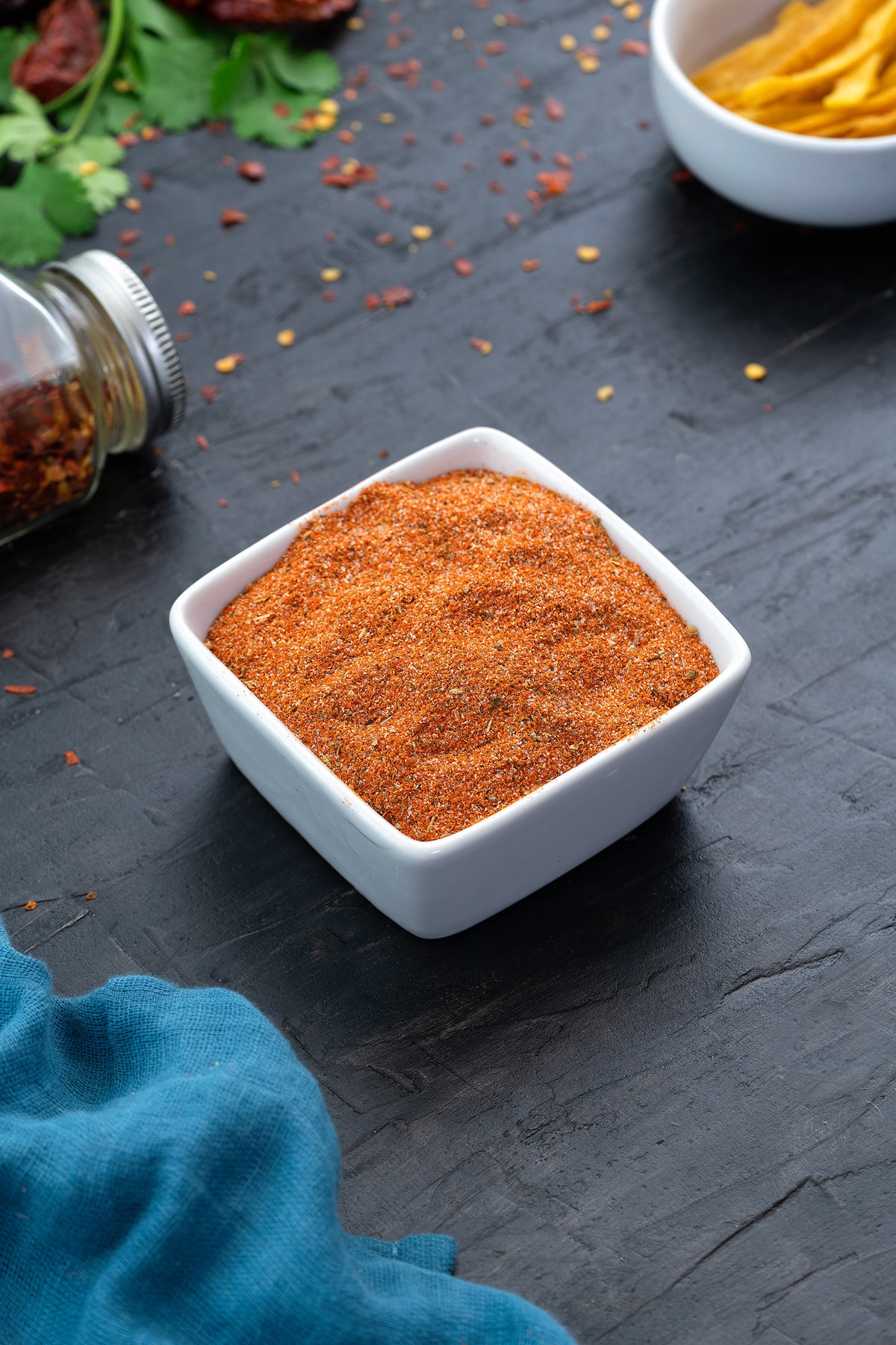 Taco Seasoning in a white square cup with few ingredients around.