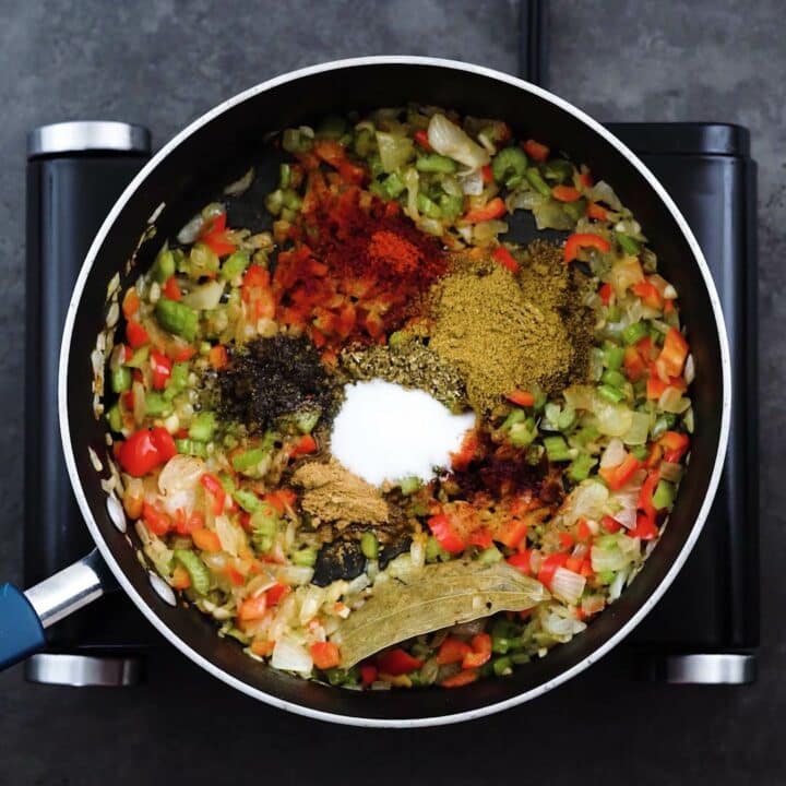 A pan with aromatics, veggies and seasoning powders.