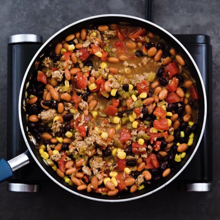 A pan with beans, corn along with bean, turkey mixture.