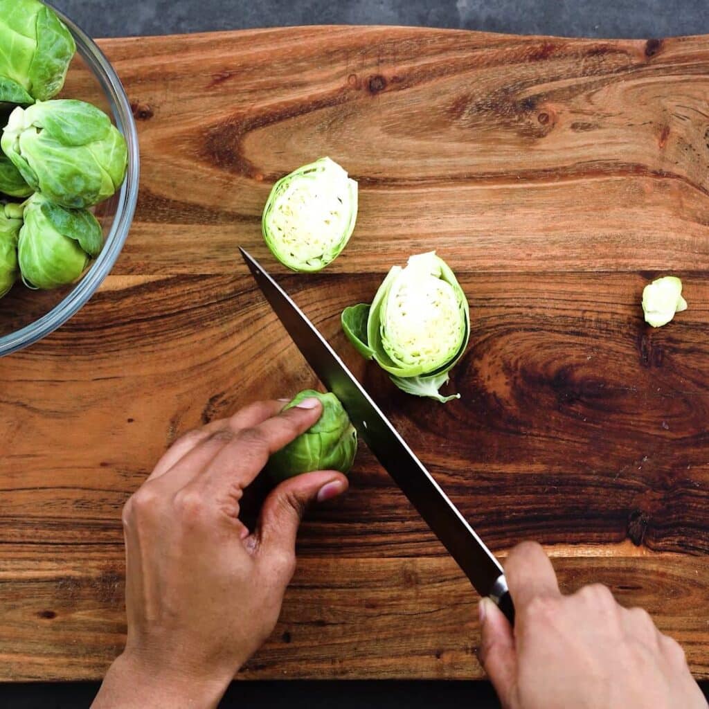 Cutting the brussels sprouts in half.