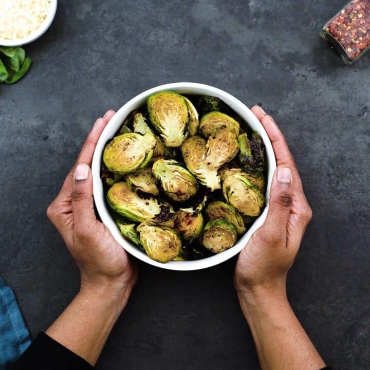 Serving the Air Fried Brussels Sprouts in a white bowl.