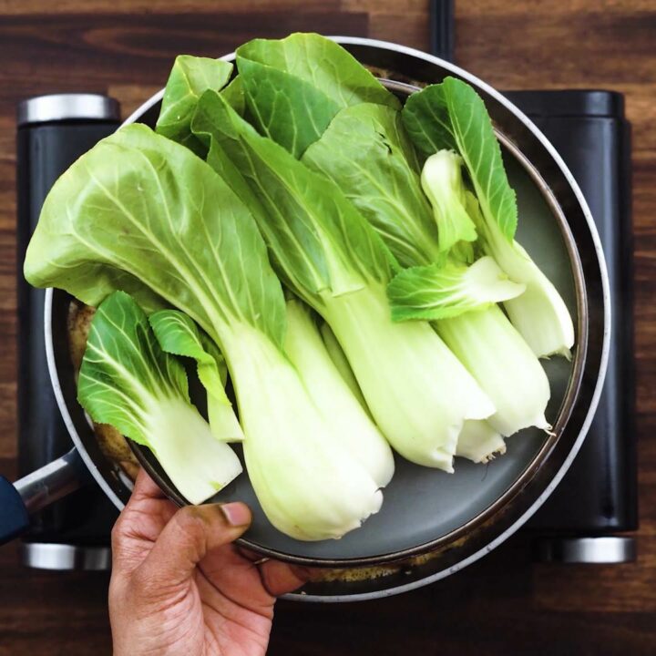 A grey plate with bok choys.