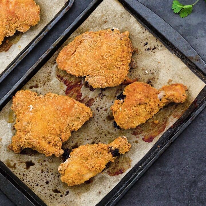 A baking tray with oven fried chicken.