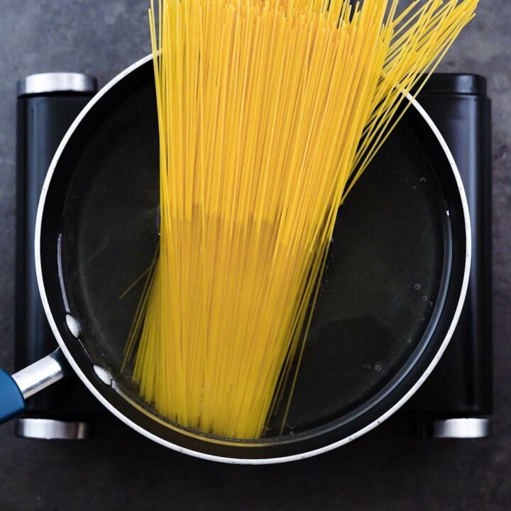 A wide pot with water and pasta.