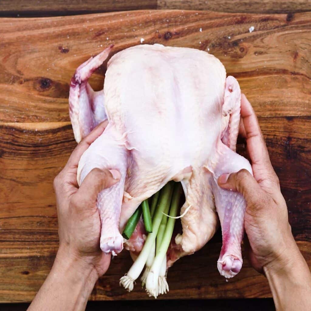 A whole chicken with aromatics.