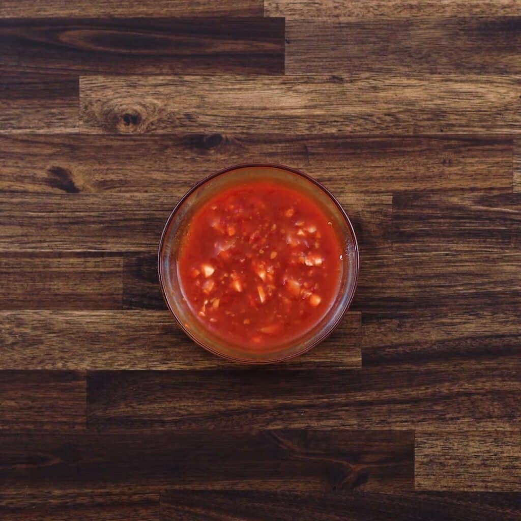 A bowl with chili sauce.