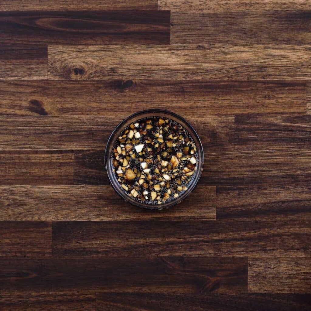 A bowl with soy dipping sauce.