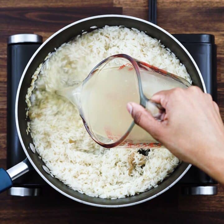 Adding the chicken broth to rice.