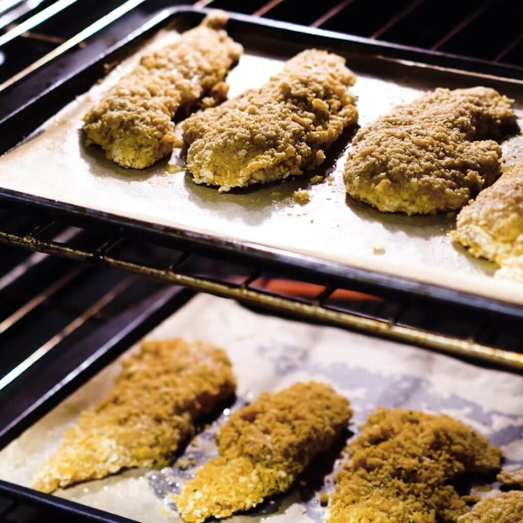 Breaded chicken tenders placed inside the oven.