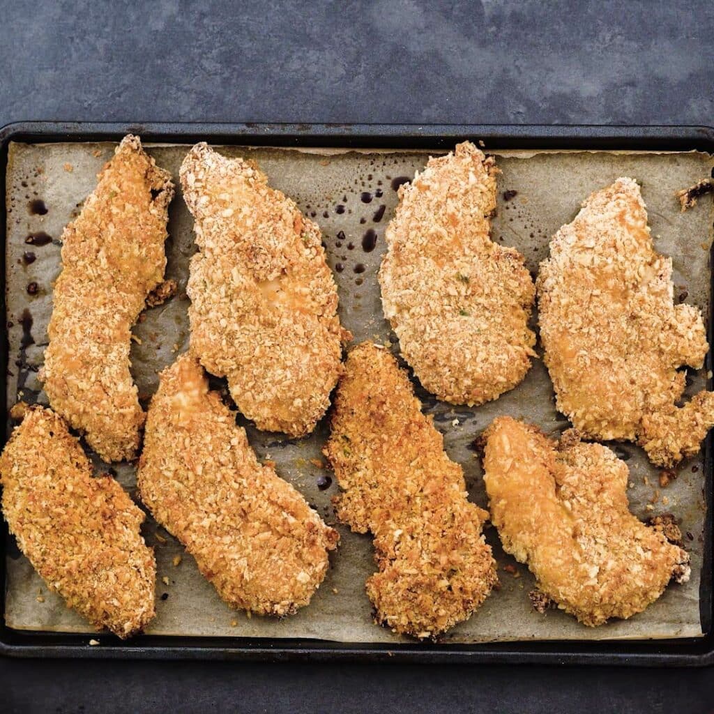 A tray with oven fried chicken tenders.