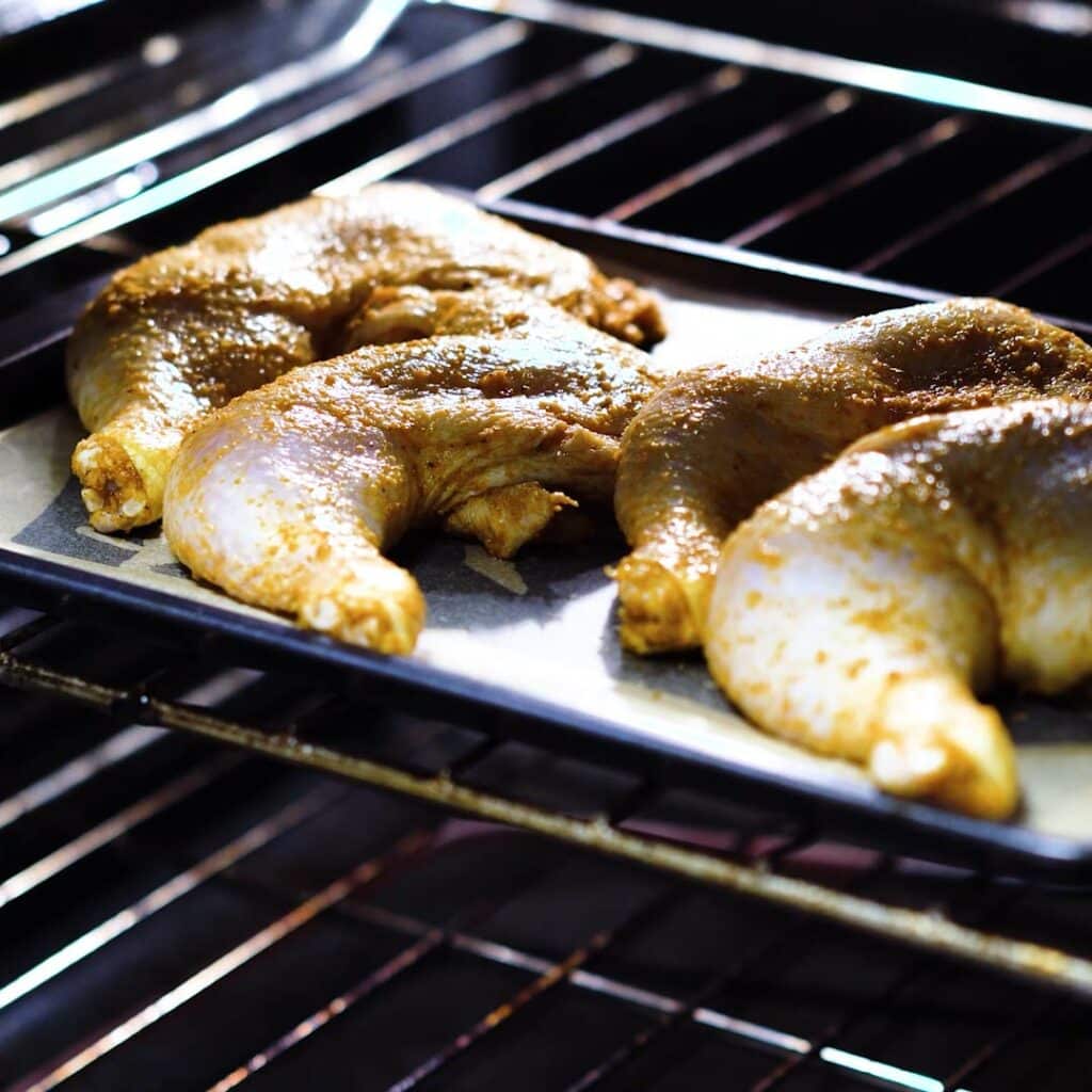 Chicken leg quarters baking inside the oven.