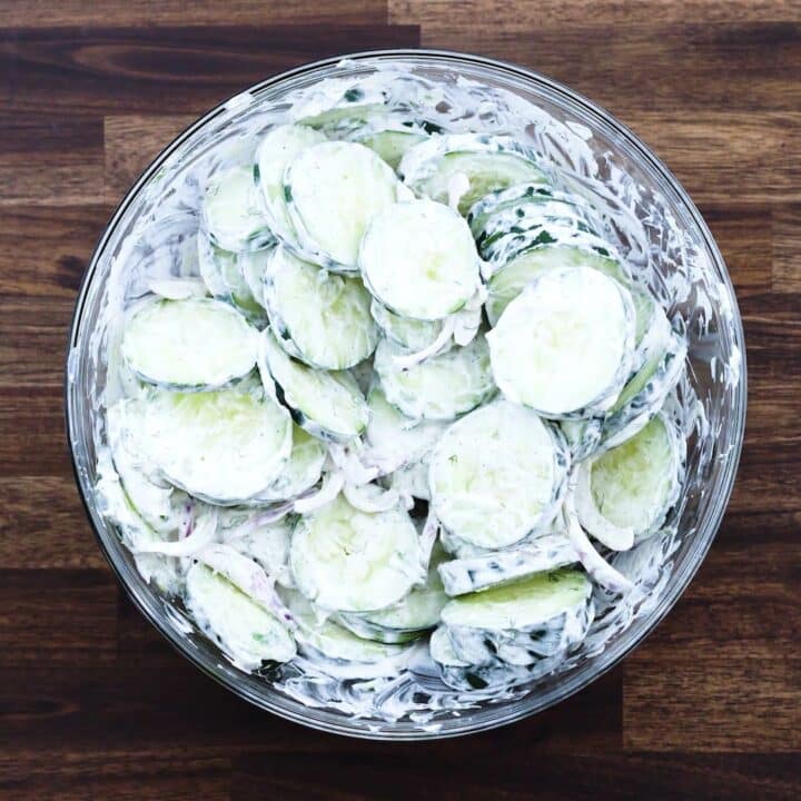 Creamy cucumber salad in a glass bowl.