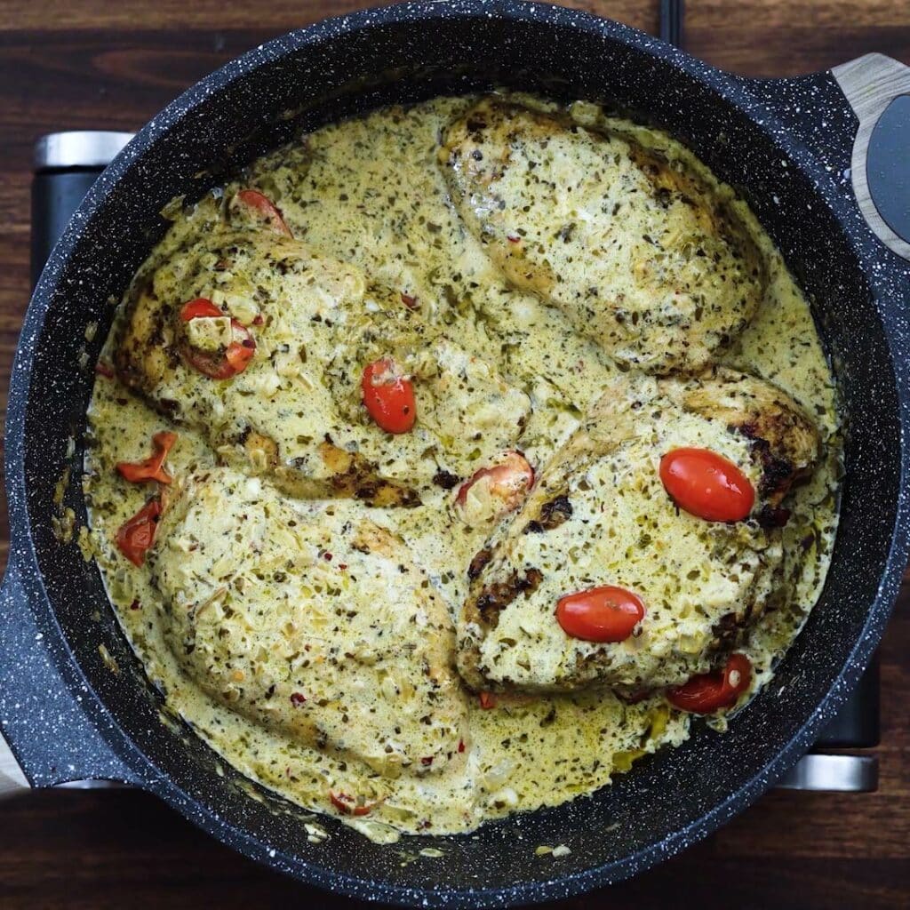 Creamy chicken pesto in a wide pan.