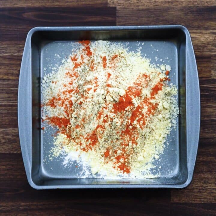 A tray with breading mix seasoned with spices.