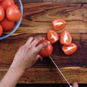 Chopping the tomatoes into small pieces.