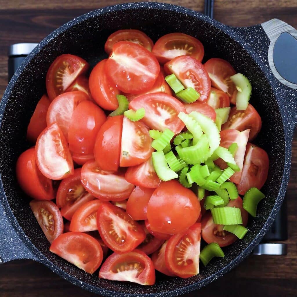 A pan with tomatoes and celery.