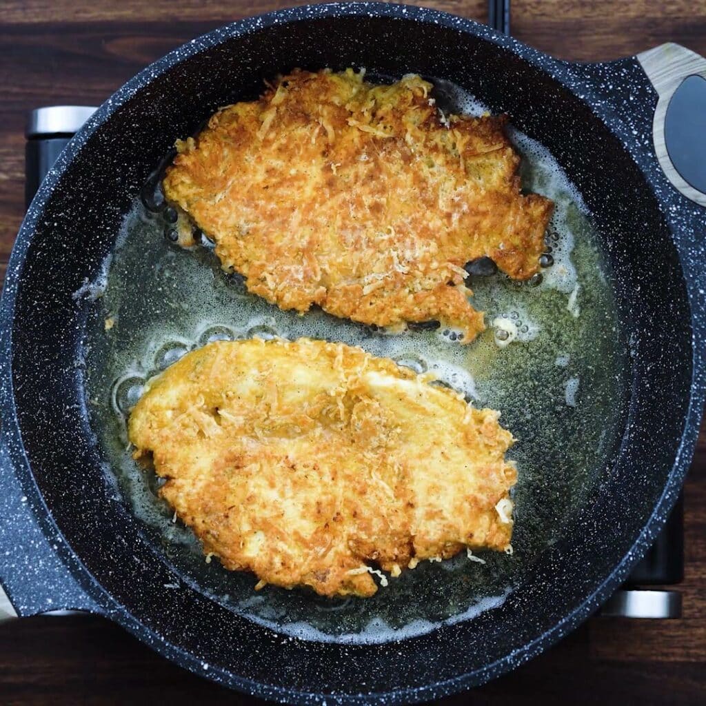 Fried Parmesan Crusted Chicken in a pan.