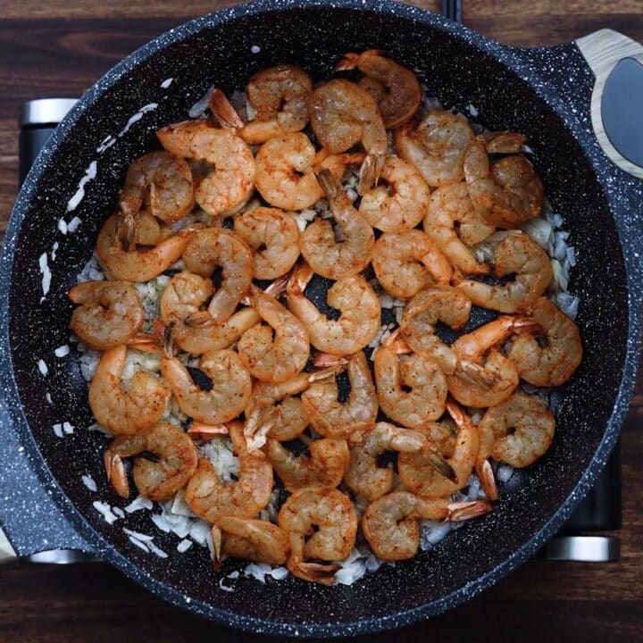 A pan with seasoned shrimp placed in single layer.