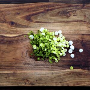 Chopped spring onions on a cutting board.