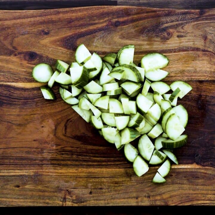 Diced cucumber on cutting board.