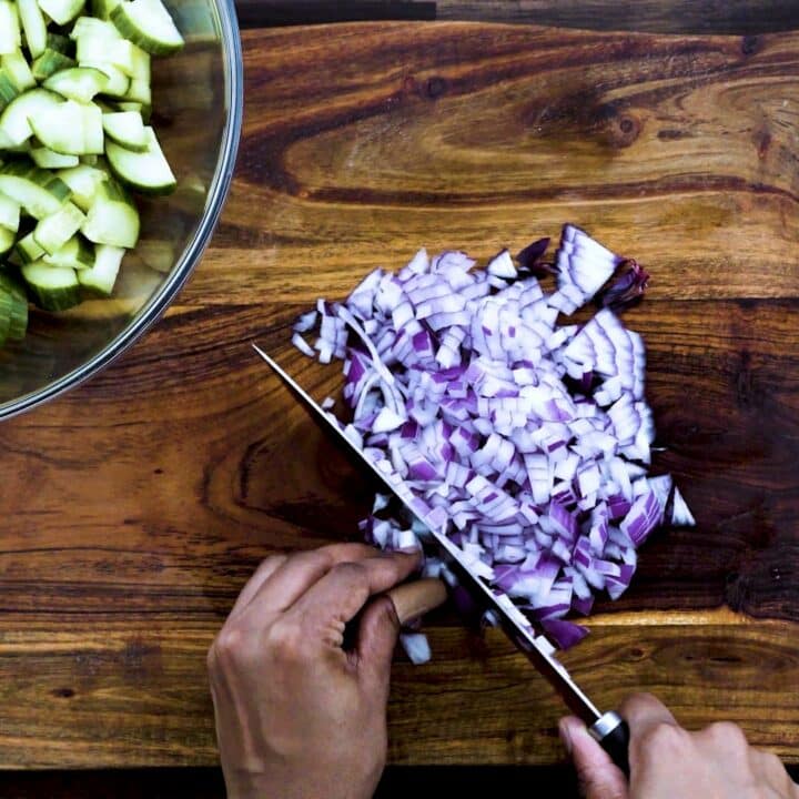 Chopping the red onions using knife.
