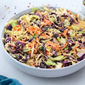 A bowl of coleslaw salad with fresh vegetables, including cabbage, carrots and greens.